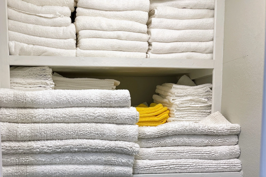 Housekeeping closet setup with departure cleaning linens for vacation rental cleaning services.